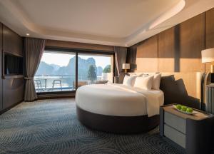 a hotel room with a large bed and a large window at M'Gloria Cruise by HAG in Ha Long