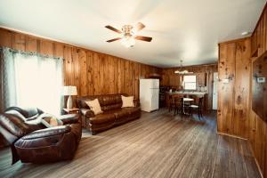 a living room with leather furniture and a ceiling fan at Turn On Inn in Lake Village