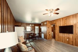 a living room with wooden walls and a ceiling fan at Turn On Inn in Lake Village