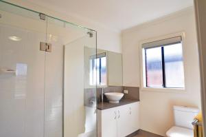 a bathroom with a glass shower and a sink at Plovers Rest in Inverloch +12 photos