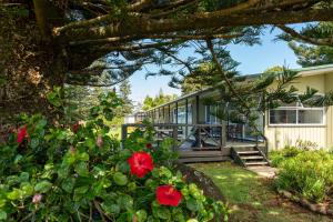a house with red flowers in the yard at Cascade Garden Apartments in Burnt Pine