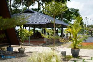 a pavilion with a table and trees in a park at River Breeze Cherai in Cochin