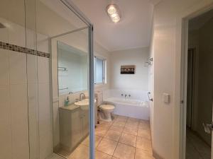 a bathroom with a shower and a toilet and a sink at Sandpiper 10 - Close to Town and Beach in Inverloch +17 photos