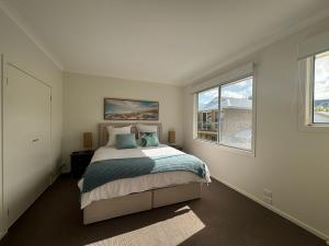 a bedroom with a bed and two windows at Sandpiper 10 - Close to Town and Beach in Inverloch
