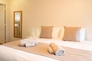 a large white bed with two towels on it at Cascade Garden Apartments in Burnt Pine +23 photos