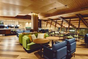 a living room with a green couch and tables at Hotel Indigo Karuizawa by IHG in Karuizawa