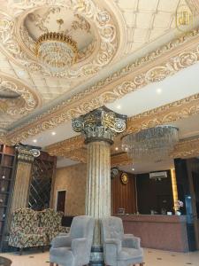 a room with a chandelier and chairs in a building at Da Rucci Hotel syariah in Medan