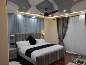 a bedroom with a large bed with white pillows at Jasminskardu in Skardu