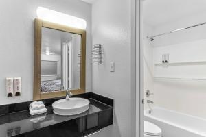 a bathroom with a sink and a toilet and a mirror at Red Roof Inn Houston - Jersey Village in Houston +32 photos