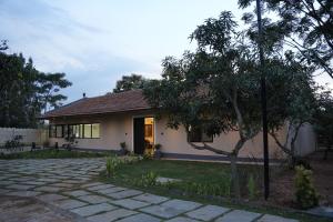 a house with a tree in front of it at Peony By Dhiya in Jadgenhalli