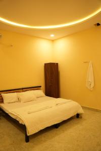 a bedroom with a bed with a yellow wall at Peony By Dhiya in Jadgenhalli +44 photos