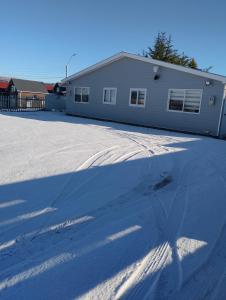 a shadow of a house on a snow covered driveway at cabañas los flamencos A in Punta Arenas