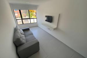 a living room with a couch and a tv at Condomínio Pérola de Porto in Ipojuca