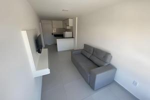 a small living room with a couch and a kitchen at Condomínio Pérola de Porto in Ipojuca