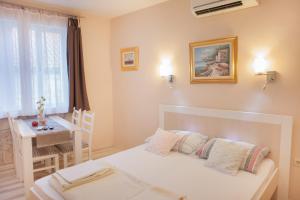 1 dormitorio con cama, mesa y ventana en Apartment BARBARA - BOJANA, en Šibenik