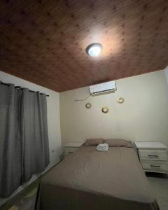 a bedroom with a bed and a wooden ceiling at La Casa de MiNi in La Ceiba