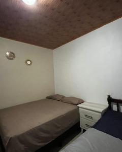 a small bedroom with two beds and a night stand at La Casa de MiNi in La Ceiba