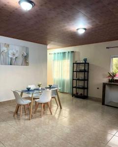 a dining room with a table and white chairs at La Casa de MiNi in La Ceiba