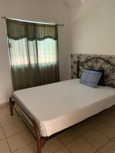 a large bed in a room with a window at Casa con alberca!! Ixtapa Zihuatanejo in Zihuatanejo
