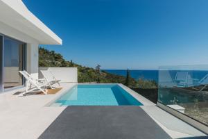 a swimming pool with a view of the ocean from a house at Zante Fiore Suites in Xirokástellon