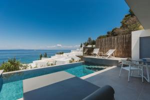 a villa with a swimming pool and a table and chairs at Zante Fiore Suites in Xirokástellon
