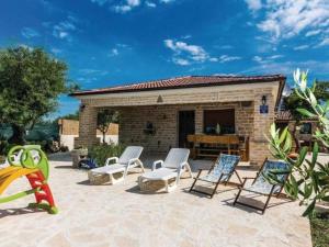 a patio with chairs and a table and a building at Three bedroom Vila with Pool in Stankovci
