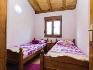 two beds in a bedroom with purple sheets and a teddy bear at Three bedroom Vila with Pool in Stankovci +16 photos
