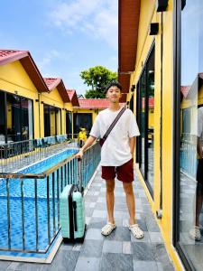 a man with a suitcase standing next to a pool at Minh chau riverside in Quang Ninh +15 photos