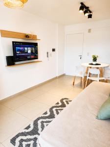 a living room with a tv on the wall at LA RIVIERA María II - CON COCHERA in Villa María