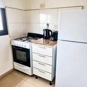 a kitchen with a stove and a refrigerator at LA RIVIERA María II - CON COCHERA in Villa María +4 photos