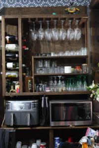 a shelf filled with glasses and a microwave at Hotel las carretas , spa y temazcal in Zacatlán