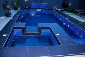 a swimming pool with blue tiles on the floor at Dream Nest in Benin City