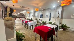 a restaurant with tables and chairs with red table cloth at Mamma Rose Hotel in Legazpi