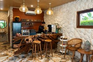 a man standing behind a counter in a bar with stools at Eywa Retreat in Uluwatu