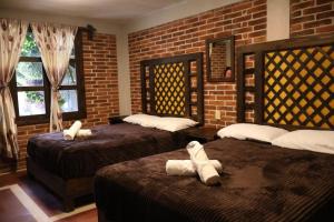 a bedroom with two beds and a brick wall at Hotel las carretas , spa y temazcal in Zacatlán