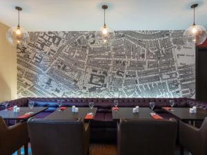 a restaurant with tables and a map on the wall at ibis Belfast Queens Quarter in Belfast