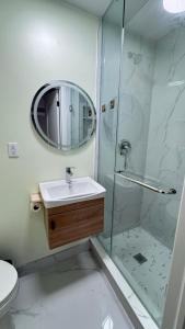 a bathroom with a sink and a shower with a mirror at Cozy room with private bathroom near subway in Toronto