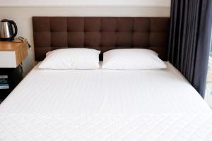 a bed with two white pillows and a brown headboard at Minh chau riverside in Quang Ninh