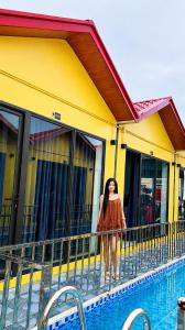 a woman standing on a balcony next to a pool at Minh chau riverside in Quang Ninh