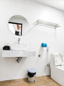 a white bathroom with a sink and a mirror at Minh chau riverside in Quang Ninh