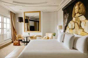 a bedroom with a large bed with a painting on the wall at Palacio de los Duques, a Gran Meliá Hotel - The Leading Hotels of the World in Madrid