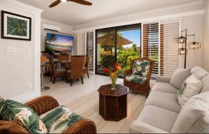 a living room with a couch and a table at Poipu Beach Condo with AC and Pool in Koloa