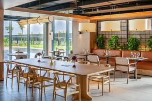 a restaurant with tables and chairs and large windows at INNSiDE by Meliá Madrid Valdebebas in Madrid