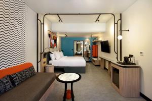 a hotel room with a bed and a couch at Tribe Bali Legian in Legian