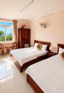 a hotel room with two beds and a window at Trung Hậu Hotel Côn Đảo in Con Dao