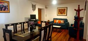 a living room with a table and a blue couch at The Green Corner Urubamba in Urubamba