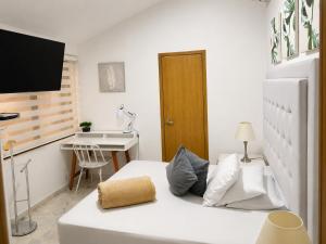 a small room with a white bed and a desk at HOTEL BELEN-La Flora- Cali Valle del Cauca in Cali +26 photos