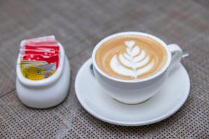 a cup of coffee on a plate next to a candle at Hotel Dreams Connect GRB 2 in Kathmandu