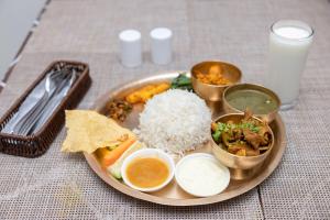 a plate of food with rice and other foods on a table at Hotel Dreams Connect GRB 2 in Kathmandu