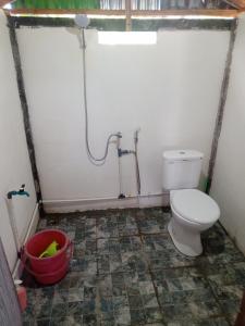 a bathroom with a toilet and a bucket in it at Jufri Homestay in Kasijala